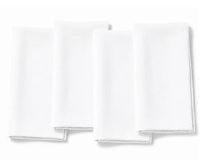 A set of four plain white fabric dinner napkins, neatly folded and displayed side-by-side against a clean white background.