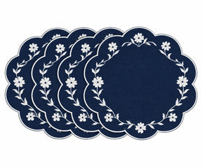 A set of five round navy blue placemats with scalloped edges, featuring a white floral wreath pattern around the border, arranged in a fanned-out display on a white background.