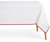 White cotton tablecloth with magenta scalloped piping trim on rectangular dining table