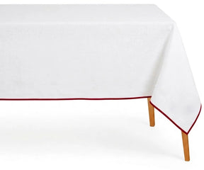White cotton tablecloth with magenta scalloped piping trim on rectangular dining table