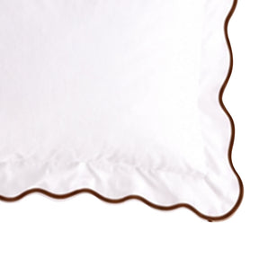 Close-up swatch of a white cotton pillow sham featuring a coffee brown scalloped embroidered edge trim