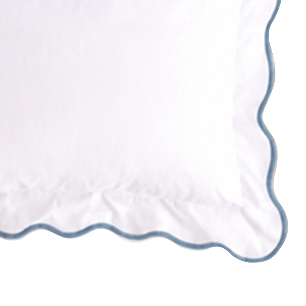 Close-up swatch of a white cotton pillow sham featuring a dusty blue scalloped embroidered edge trim.