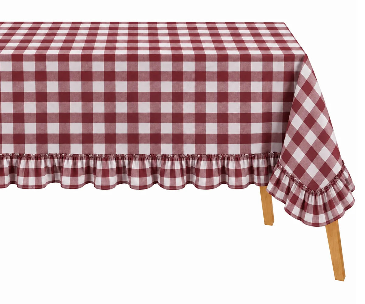 A dark red and white checkered tablecloth with a ruffled hem, draped over a table with visible wooden legs against a plain white background.
