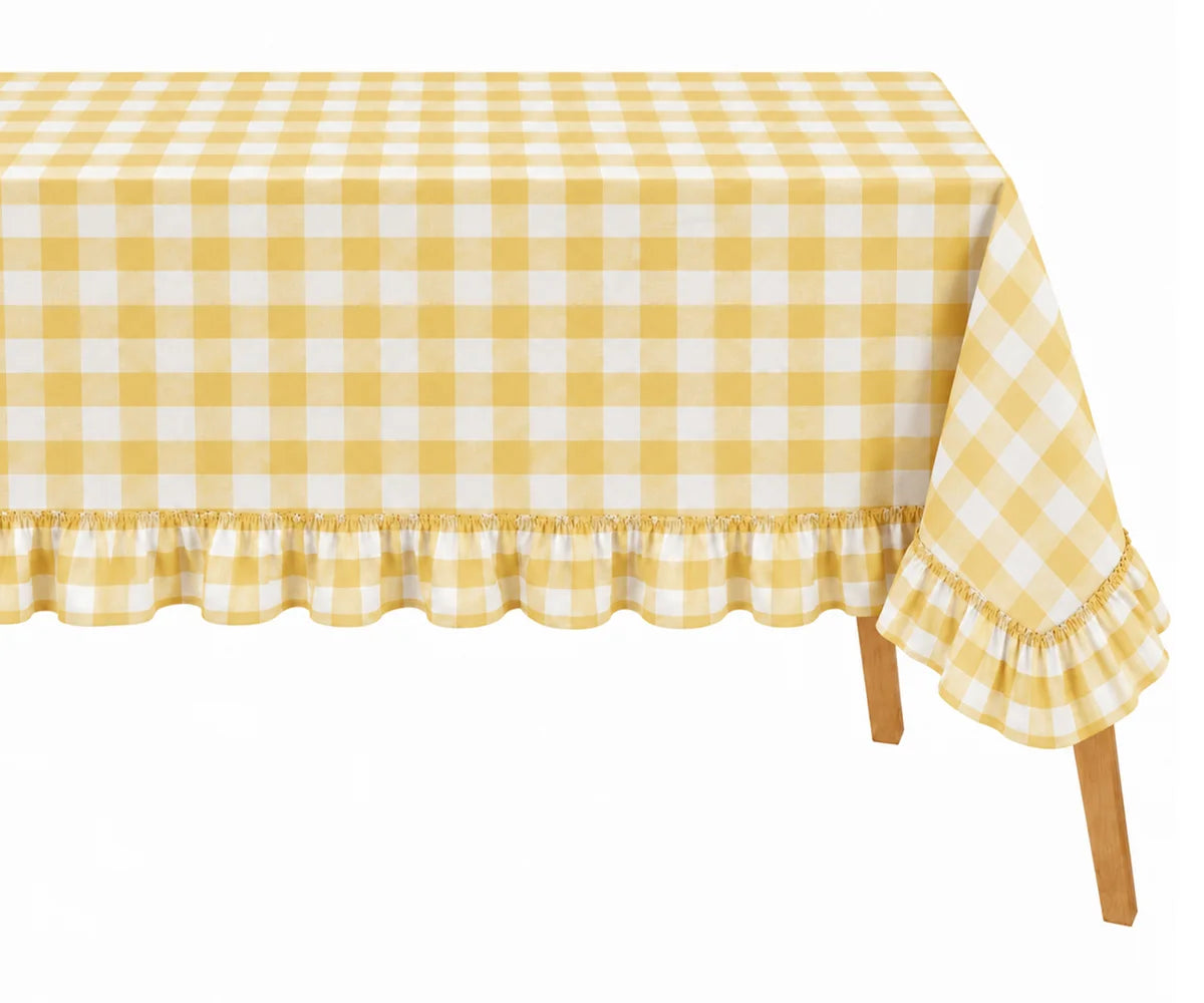 A yellow and white gingham checkered tablecloth with a ruffled hem, draped over a table with wooden legs visible against a plain white background.