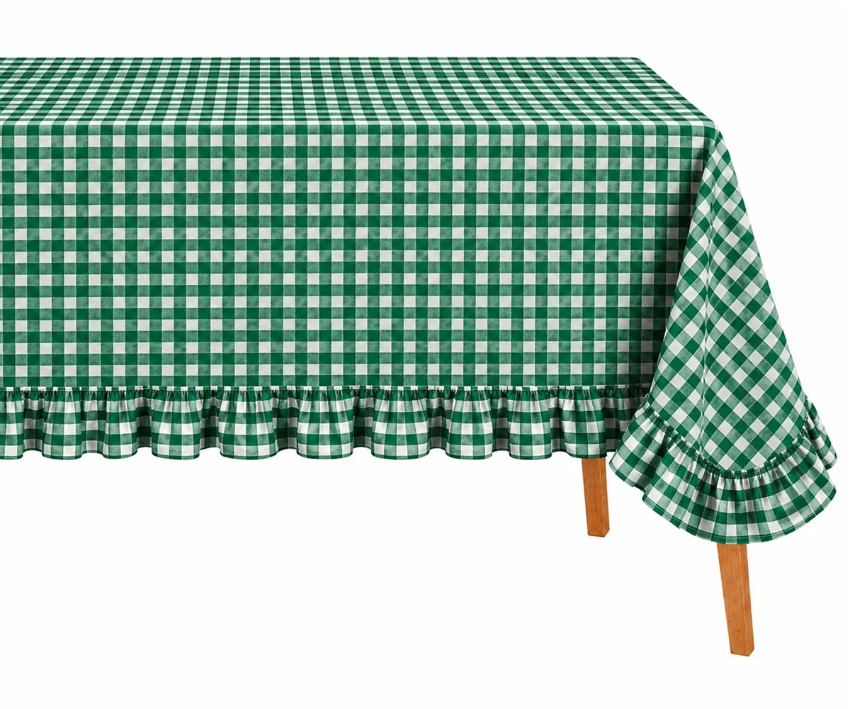 Green and white gingham checkered tablecloth with a ruffled hem, draped over a table with visible wooden legs against a plain white background.