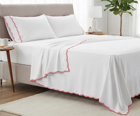 Luxury red cotton sheet set with scalloped trim, deep pocket fitted sheet and matching pillowcases