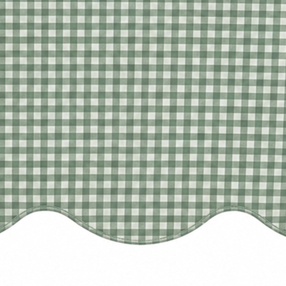 Close-up of sage green and white small checkered cotton tablecloth fabric highlighting the decorative scalloped edge border.