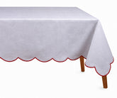 Elegant red cotton tablecloth with embroidered scalloped edges styled on a festive dining table.