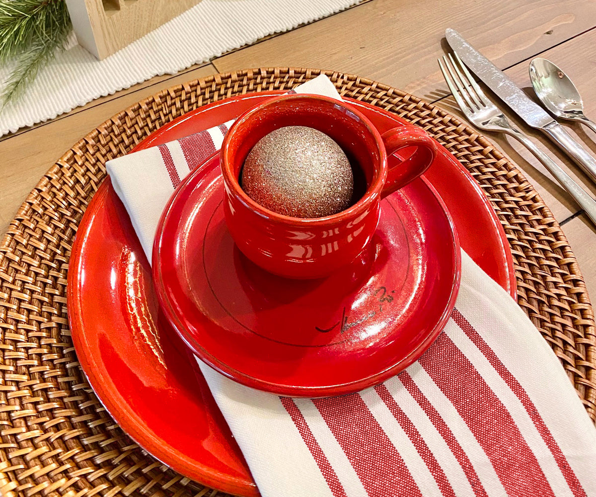 Table setting featuring a red plate and a bistro napkin