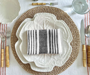 Collection of white and red striped linen dinner napkins displayed on a kitchen surface