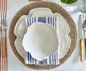 White plate on a table setting with a blue and white striped linen napkin