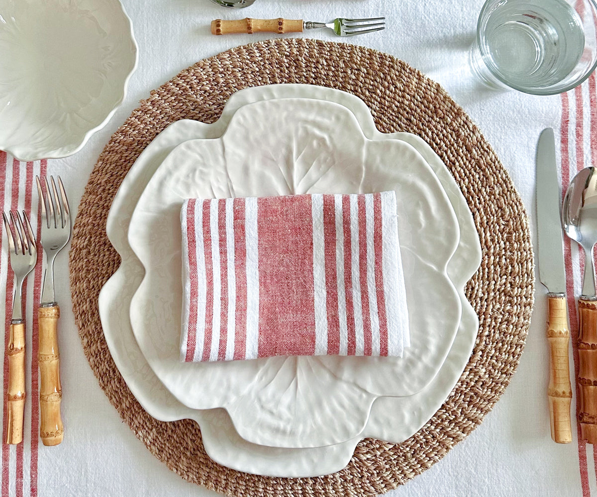 A dining table setting with a linen napkin showcasing red and white stripes