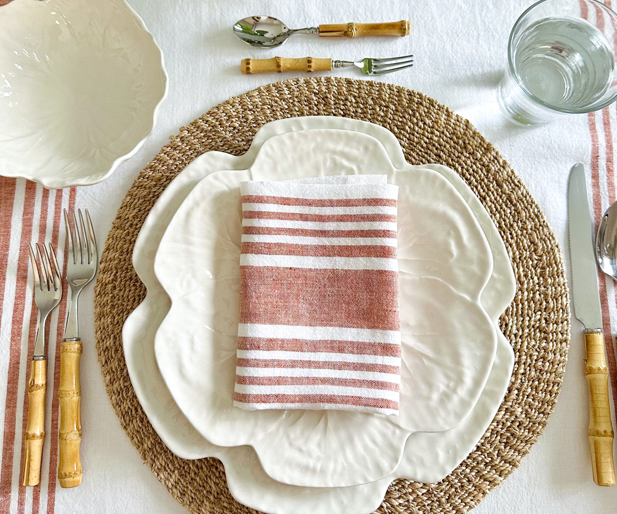 A table setting with a red and white striped linen napkin arranged neatly
