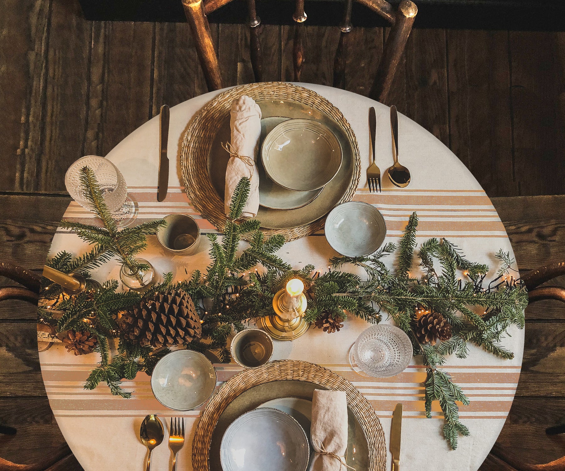 Table setup with round outdoor tablecloth and pine cone decor