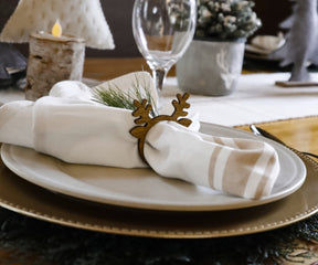 Restaurant napkin included in a place setting with a white plate and deer head decor