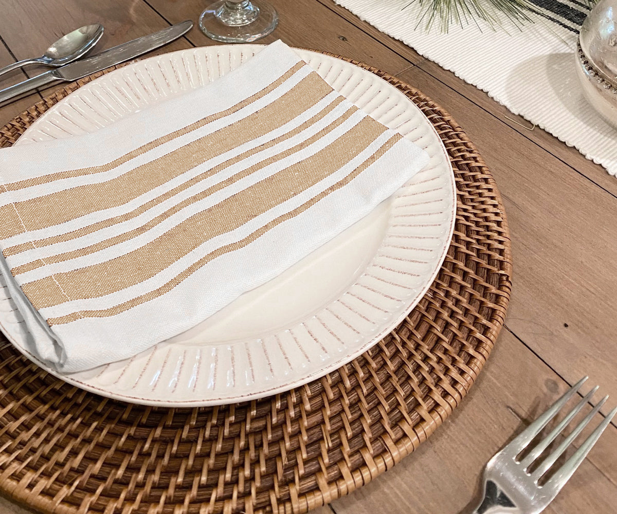 Table setting featuring a white plate and a brown bistro napkin