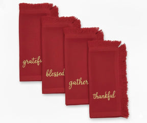 Rich dark red embroidered napkins with gold thread and soft fringed finish for festive tables