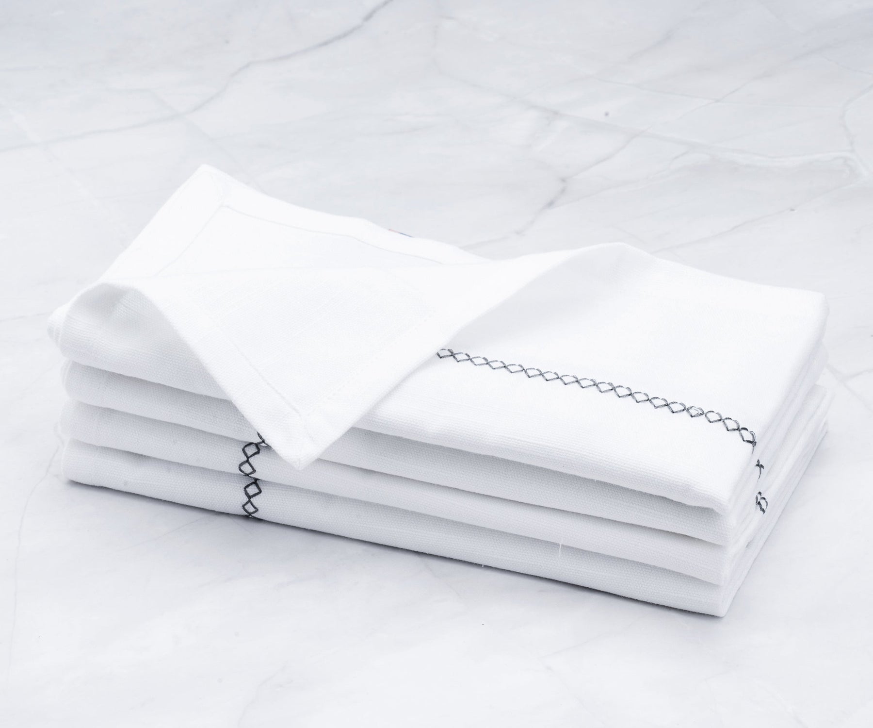 There are cloth dinner napkins, Vanity Fair dinner napkins, neatly folded dinner napkins, white cotton napkins, and instructions on how to fold napkins for dinner.