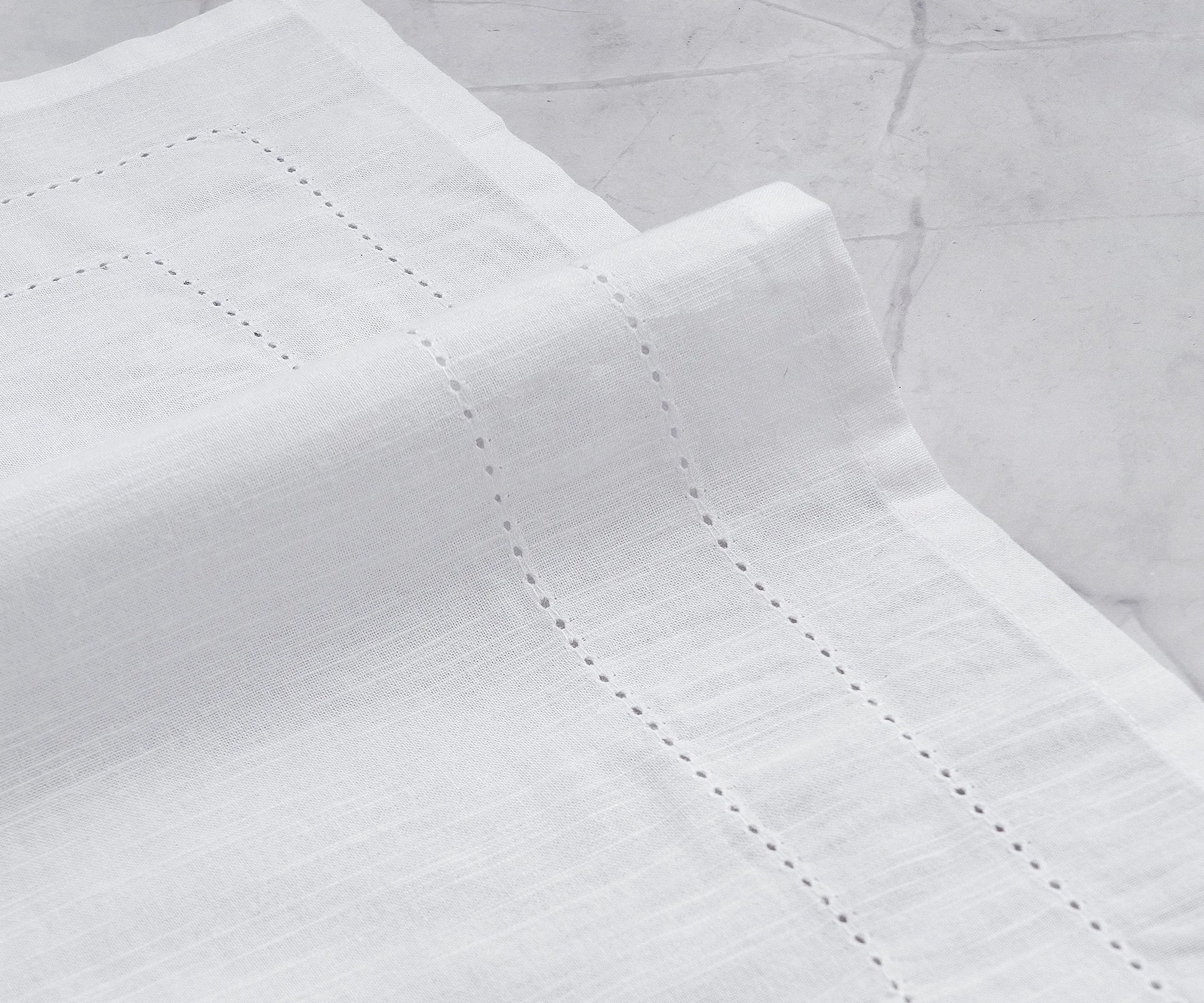 Set of 12 hemstitched cloth napkins displayed on a dining table