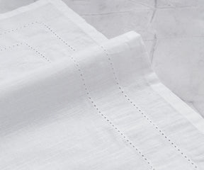 Set of 12 hemstitched cloth napkins displayed on a dining table