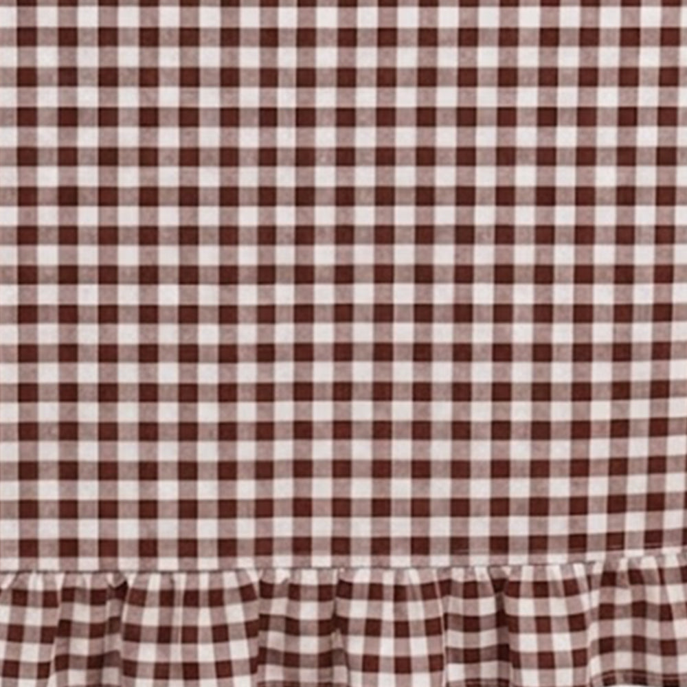 Detailed swatch of ruffle edge tablecloth fabric showcasing classic gingham pattern and stitching