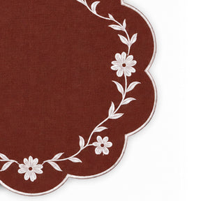brown scalloped placemat with white floral vine embroidery