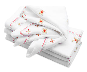 White dinner napkins elegantly draped over silver napkin rings, enhancing a modern table setting.