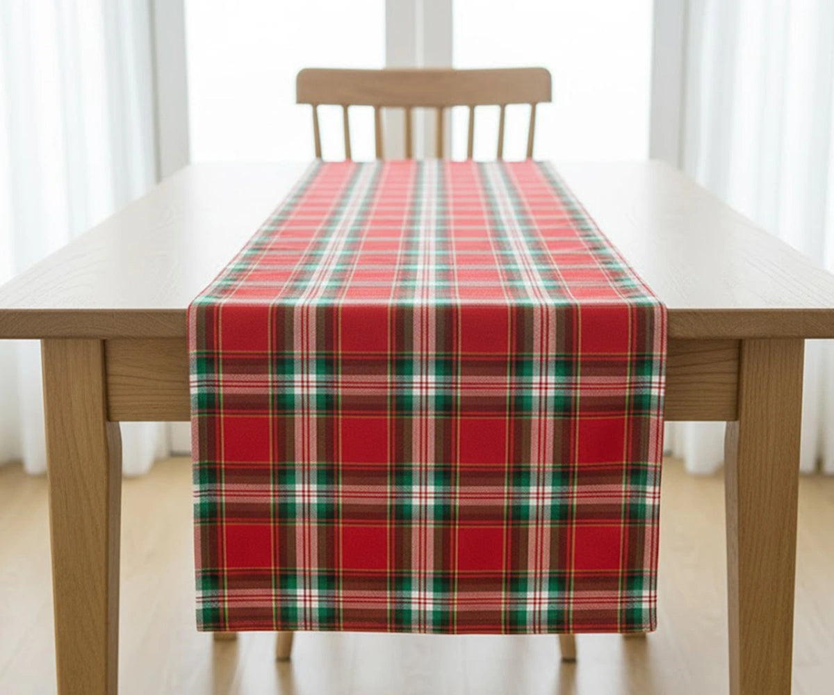 Green tartan plaid cotton table runner with red, navy, and yellow checks adding classic warmth and festive charm to a Christmas dining table.