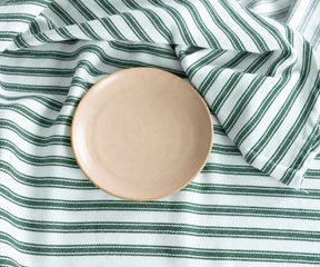 Green round tablecloth with classic striped design
