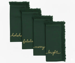 Green embroidered Christmas napkins with gold stitching and fringed edges for festive table décor