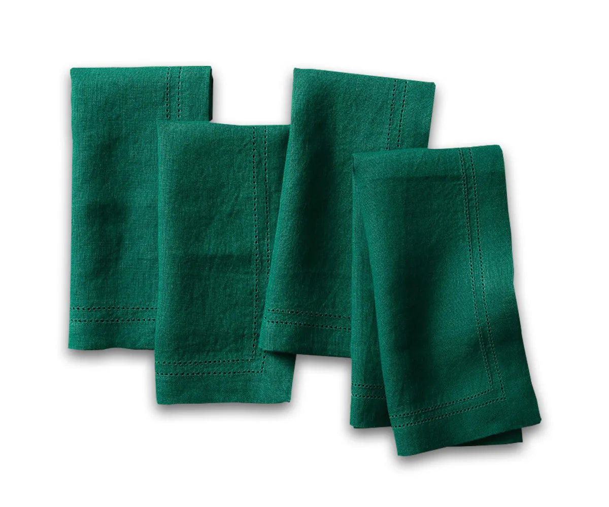 Green linen hemstitch napkins neatly folded on a dining table setup