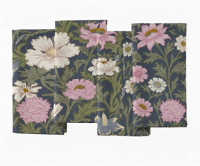 Set of floral printed cotton napkins featuring pink and white flowers with green leaves on a dark blue base.