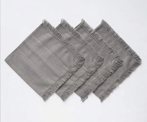 Reusable fringed cotton napkins with soft fabric construction, ideal for dinner tables, gatherings, and everyday dining.
