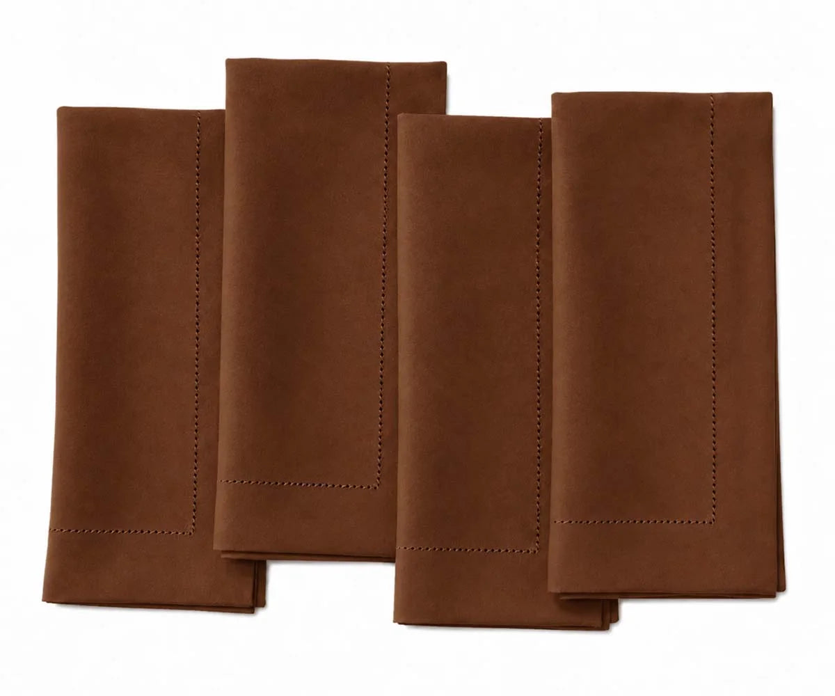 Set of four coffee brown hemstitch dinner napkins neatly folded side by side on a white background