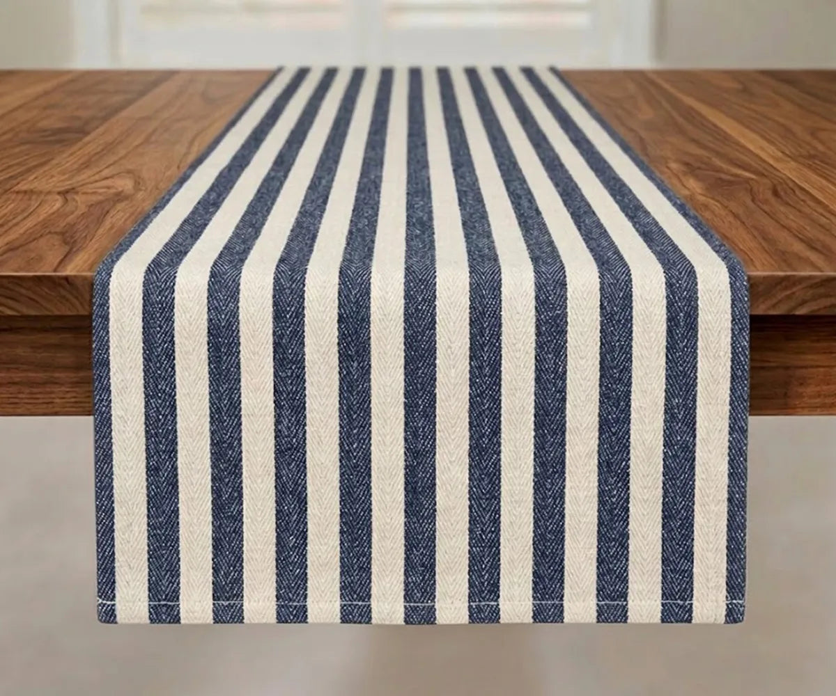 Striped farmhouse table runner in 100% cotton with blue stripes on white base, herringbone weave, styled on wooden dining table