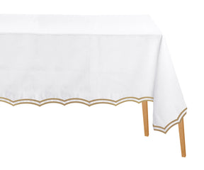 Beige embroidered cotton rectangle tablecloth with scalloped edges on dining table