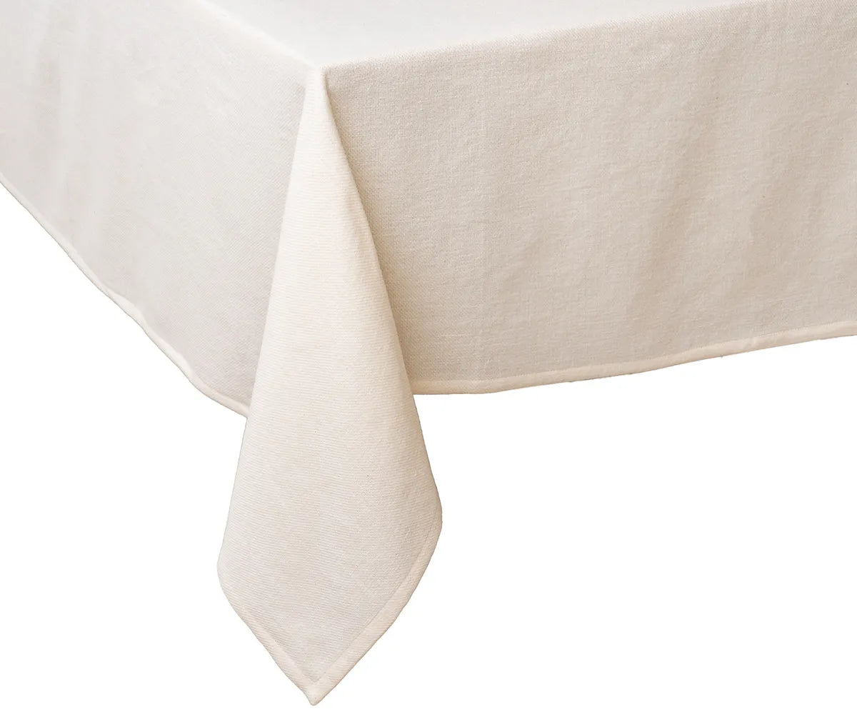 Elegant ivory cotton tablecloth on a rectangular dining table, styled with neutral runners, wooden chargers, and floral centerpieces for a sophisticated dining setup.