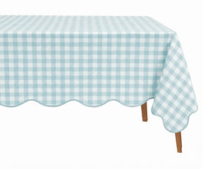 Light blue and white checkered cotton tablecloth with a decorative scalloped edge draped over a table.