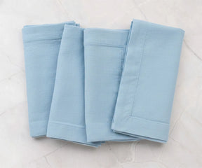 Folded light blue cotton linen napkins with plain solid finish, reusable dinner napkins for everyday table styling
