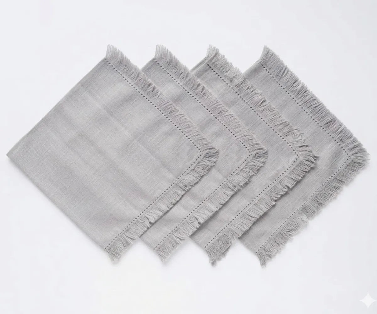 Durable cotton cloth napkins with decorative fringed edges, suitable for restaurants, events, and home dining setups.