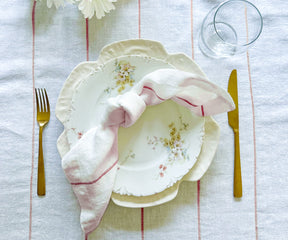 Achieve a polished table arrangement by mastering the art of folding dinner napkins with rings and displaying them elegantly in a stylish napkin holder.