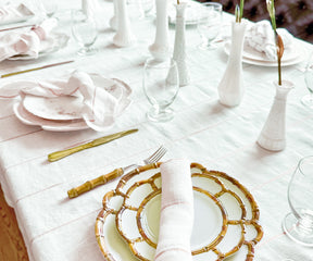 Enhance your table setting with beautifully folded dinner napkins using rings, elegantly presented in a stylish napkin holder for a touch of refinement.