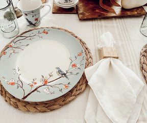 Elegant white linen napkin placed under a dining plate and beside a wine glass