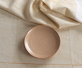 Beige block print tablecloth with neutral dinnerware and floral centerpiece