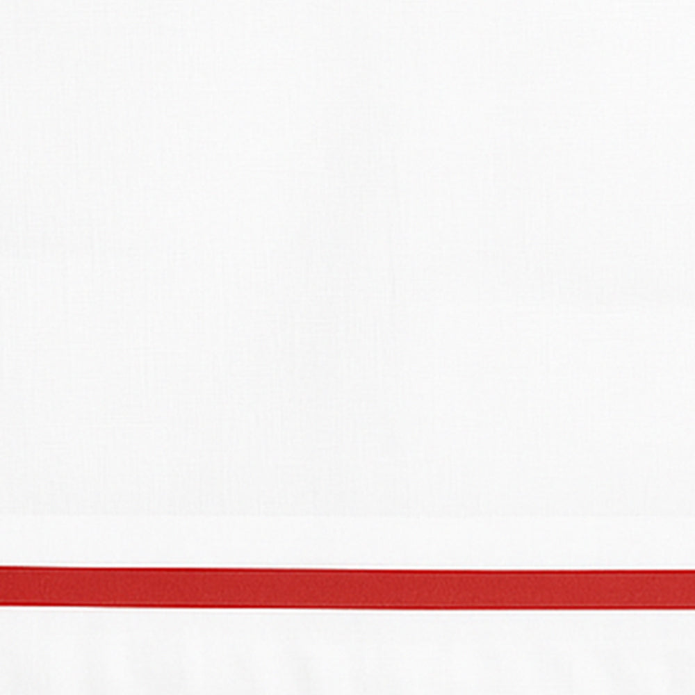Close-up detail of white linen pillowcase with a red embroidered border line.