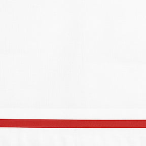 Close-up detail of white linen pillowcase with a red embroidered border line.