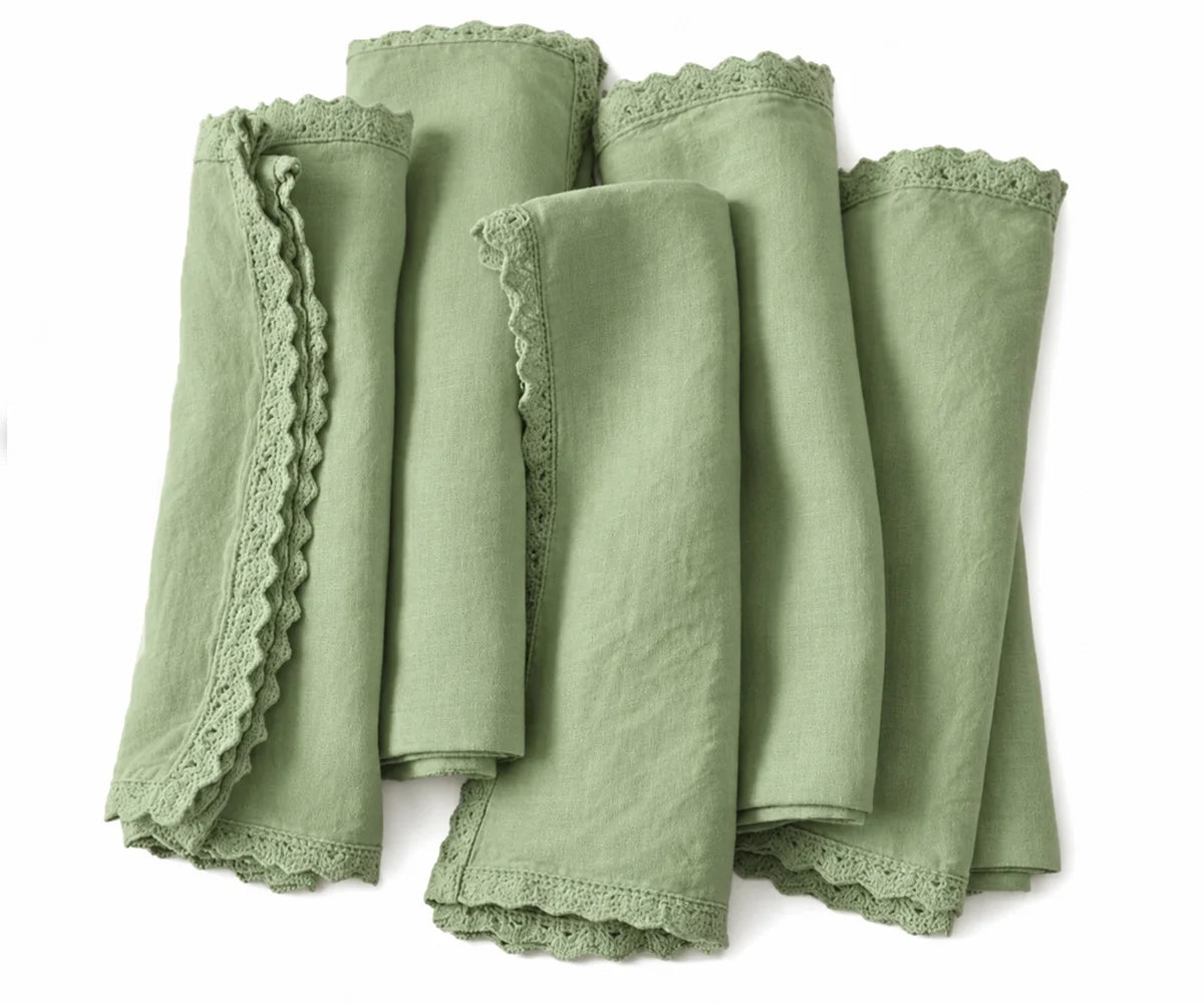 Sage green linen cloth napkins with decorative lace edges for everyday dining and festive tables.