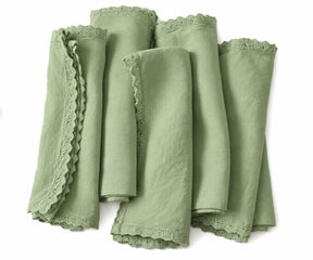 Sage green linen cloth napkins with decorative lace edges for everyday dining and festive tables.