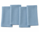 Cornflower blue plain linen napkin arranged on dining table, showing soft textured fabric