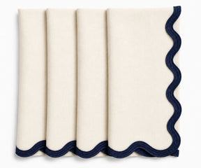 Ivory European linen scalloped napkins with navy blue embroidered edges, elegant reusable cloth dinner napkins for weddings, coastal dining, and classic table settings.